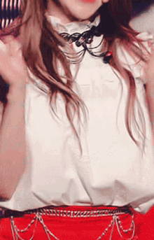 a woman wearing a white shirt and red skirt is holding a microphone .