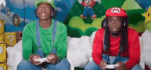 two men dressed as mario and luigi are playing video games .
