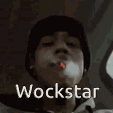a man is smoking a cigarette and the word wockstar is on the screen