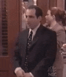 a man in a suit and tie is shaking hands with a woman in a suit