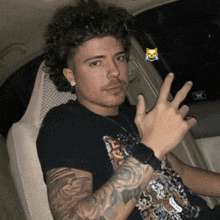 a man with curly hair is sitting in a car and making a funny face