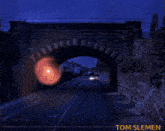 a picture of an ufo flying over a bridge with tom slemen written on the bottom right
