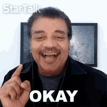 a man wearing headphones says okay with his finger