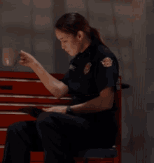 a woman in a firefighter uniform is sitting in front of a red drawer